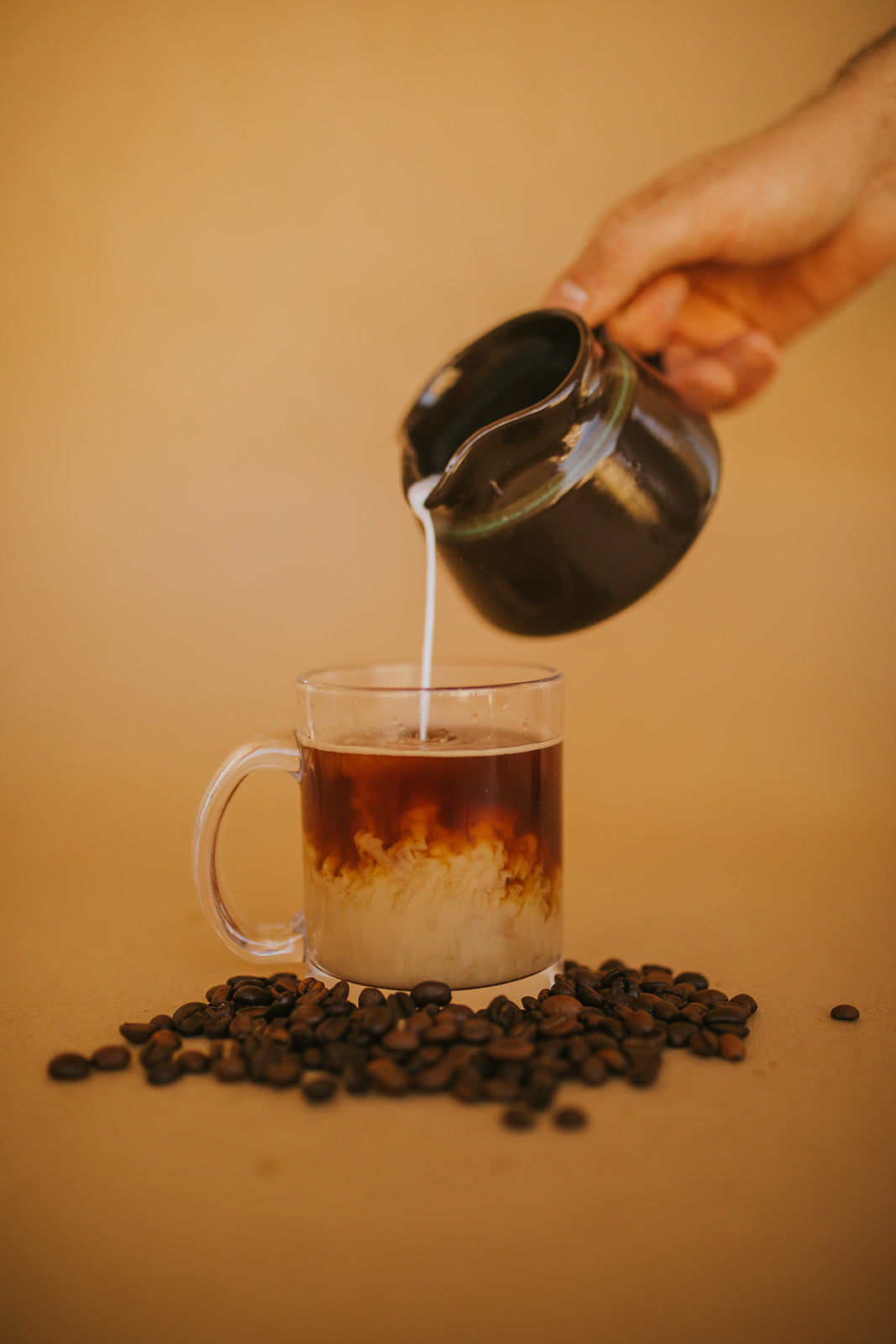 clear glass coffee mug with Brycks coffee milk and cream coffee beans